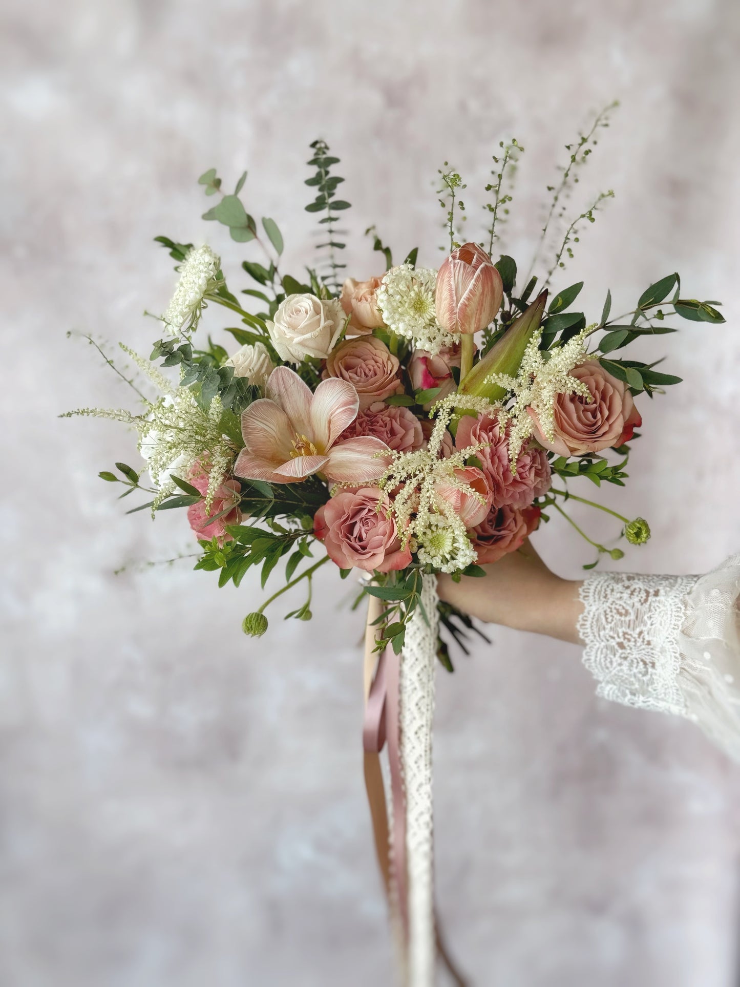 A close-up of lush greenery and blush blooms intertwined, highlighting the bouquet’s airy and graceful movement.
近距离拍摄绿叶与浅粉花朵交错相融,展现捧花的轻盈与优雅感。