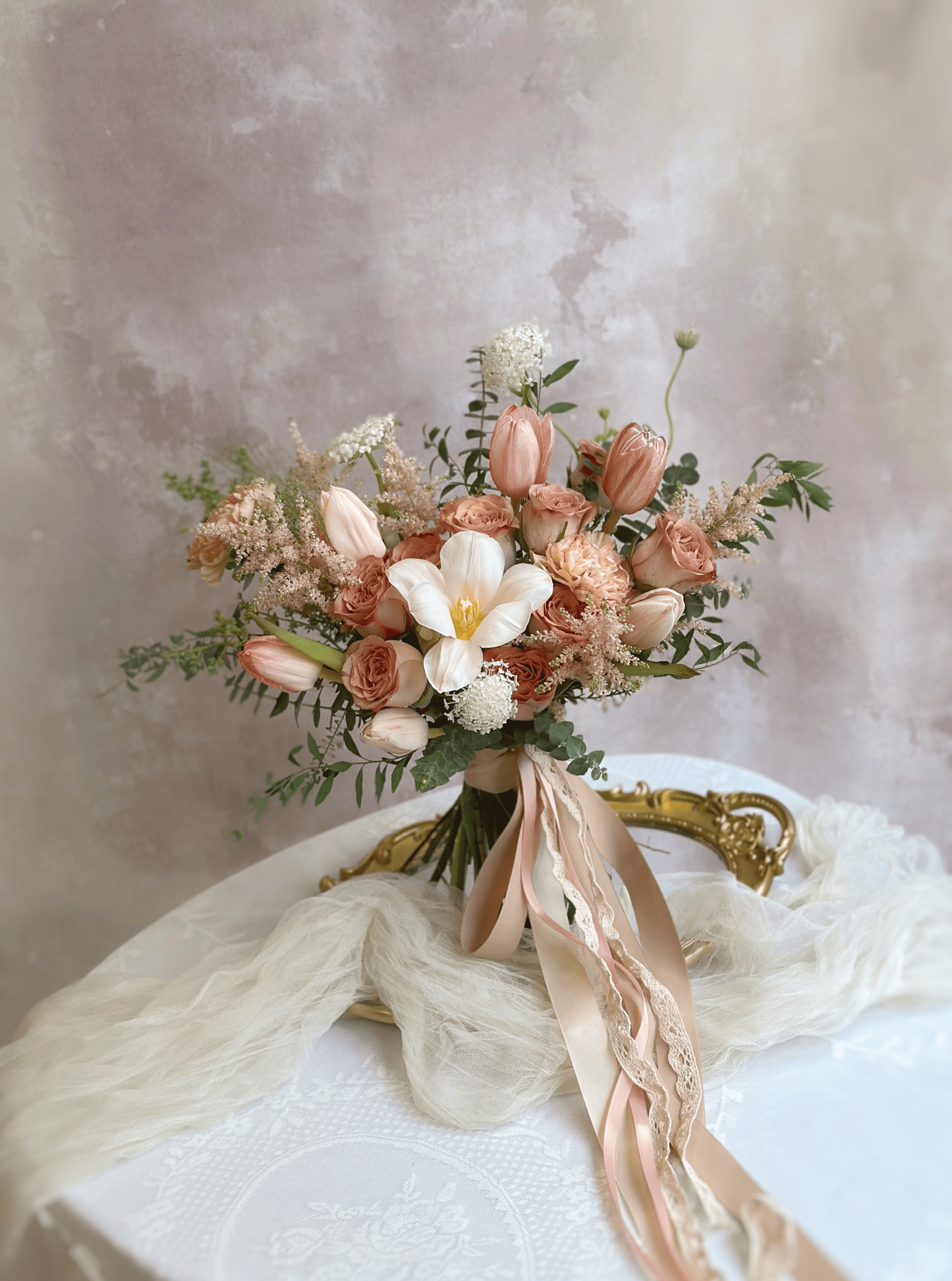 A free-form bridal bouquet with wispy greenery and soft blush blooms, creating a natural and effortless garden feel.
自由形态的新娘捧花,结合轻盈绿叶与柔和浅粉花朵,营造自然随性的花园氛围