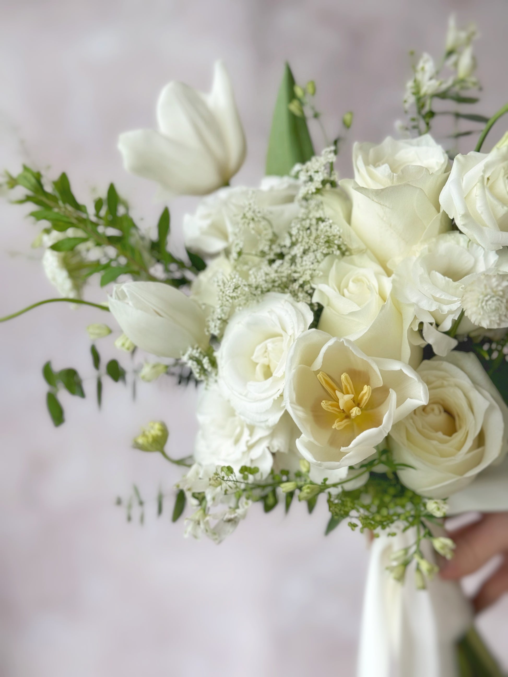 Close up view of wispy white fresh flowers bridal bouquet, Sophisticated white wedding bouquet with airy florals and fresh green accents, perfect for a timeless bridal look.
柔美花瓣与茂密绿叶交织,呈现自然精致的捧花设计