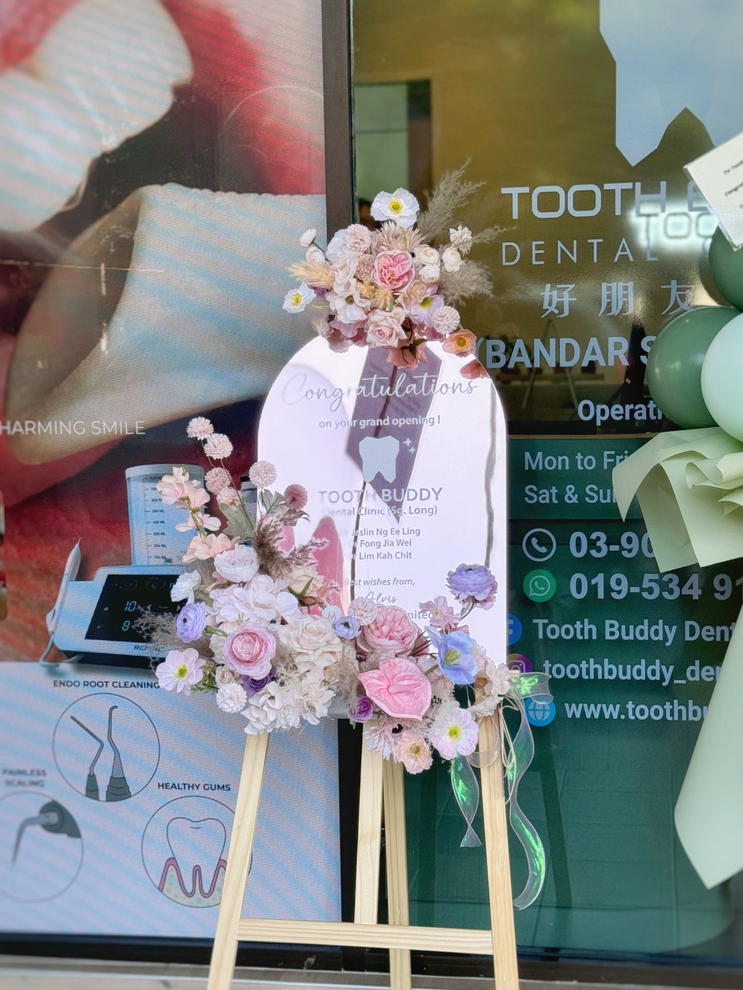 faux flower arrangement in pastel pink theme and acrylic mirror stand for grand opening in front view