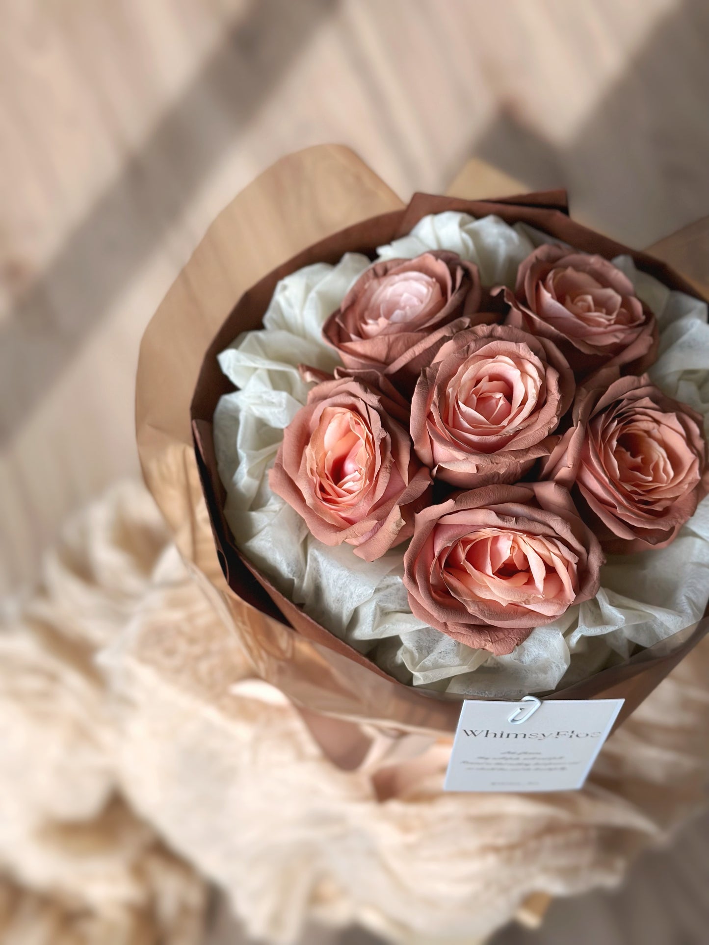 Close-up of pink mocha rose petals with hand-sprayed brown tones, highlighting their aged blush effect and delicate texture.
特写镜头展示粉咖玫瑰花瓣,棕色喷涂细节营造岁月感,花材质地柔美细腻。