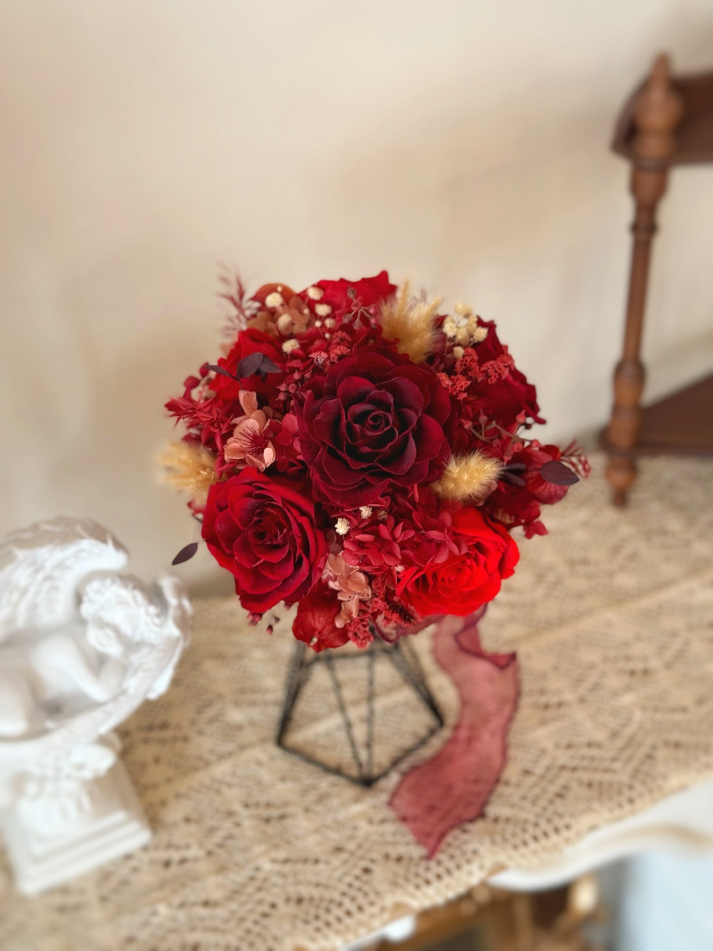 Top-down view showing symmetrical arrangement of deep red and cream preserved roses in a round bridal design.
俯视图展示对称排列的永生玫瑰,酒红与奶油色调相互衬托,典雅大方