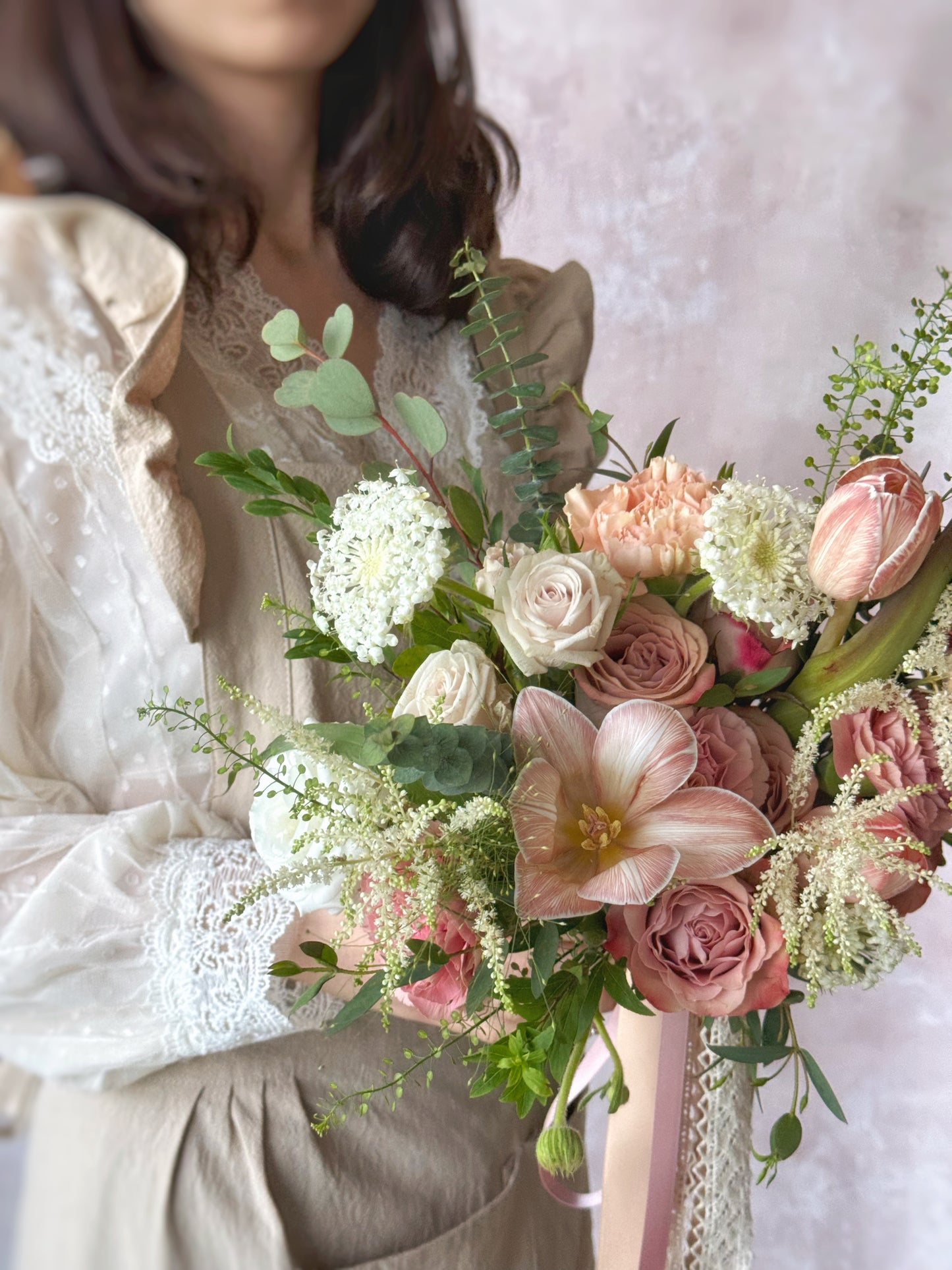 The bouquet’s delicate layers of flowers and greenery create an elegant silhouette from every angle.
捧花层次丰富,花朵与绿叶交错,每个角度都展现优雅轮廓。