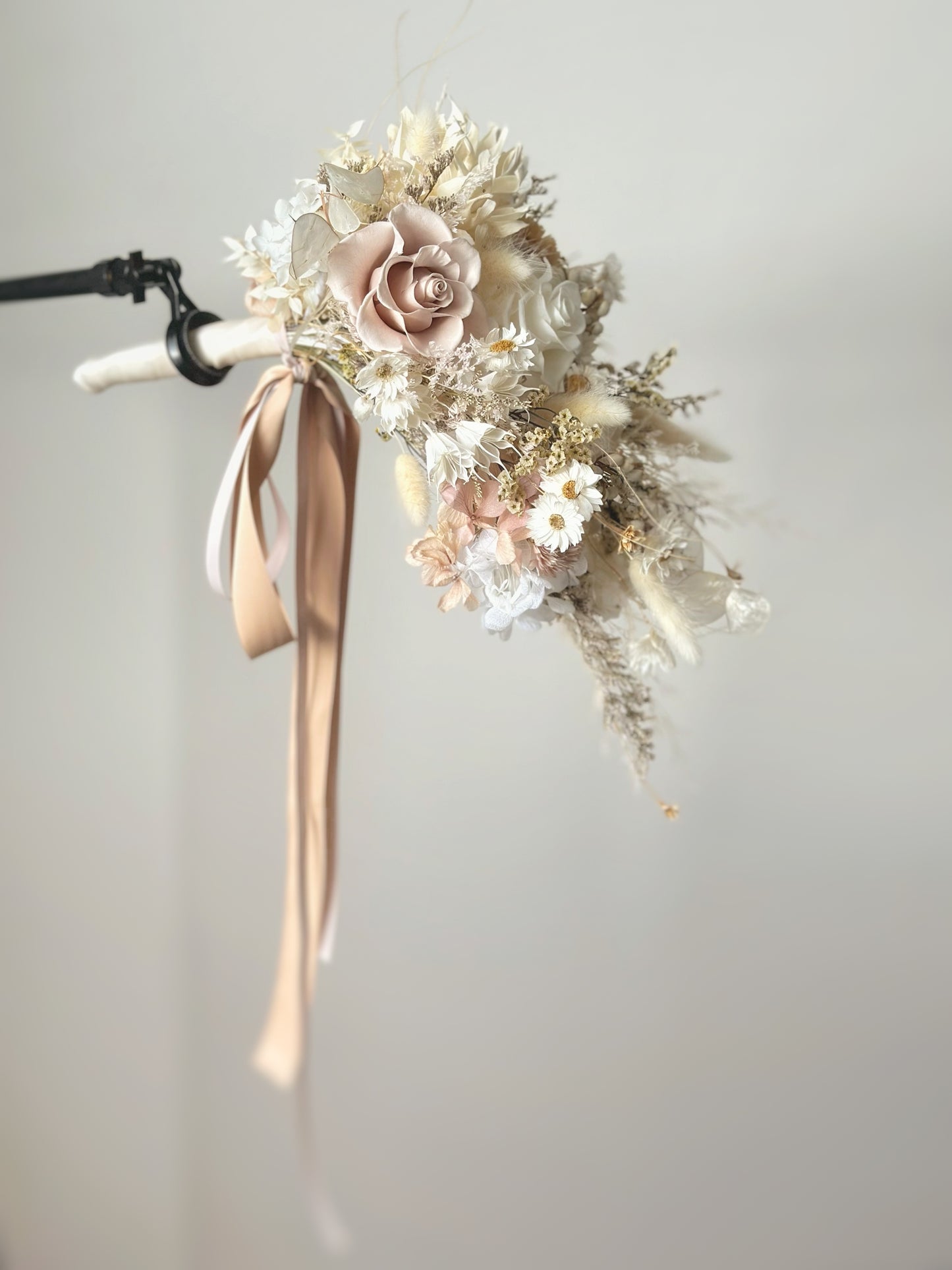 The cascading teardrop bouquet flows beautifully as the bride holds it at her side, creating a soft, airy look.
新娘侧手持水滴形手捧花，花朵自然垂坠，营造出轻盈优雅的氛围。