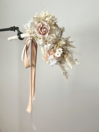 The cascading teardrop bouquet flows beautifully as the bride holds it at her side, creating a soft, airy look.
新娘侧手持水滴形手捧花，花朵自然垂坠，营造出轻盈优雅的氛围。