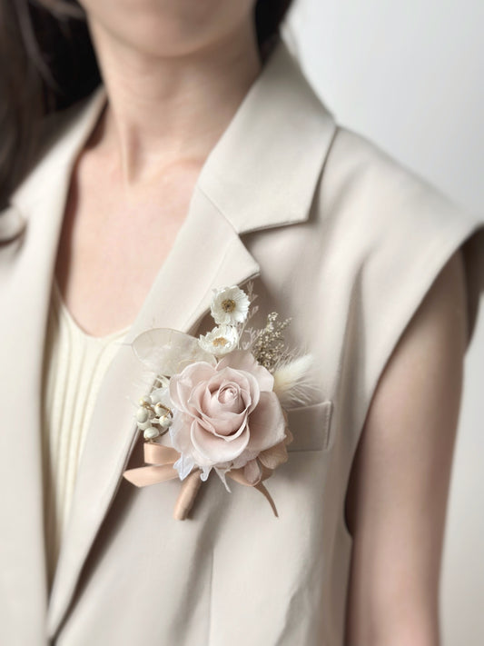 Elegant ivory tone preserved rose boutonniere for the groom, showing it worn on a khaki blazer