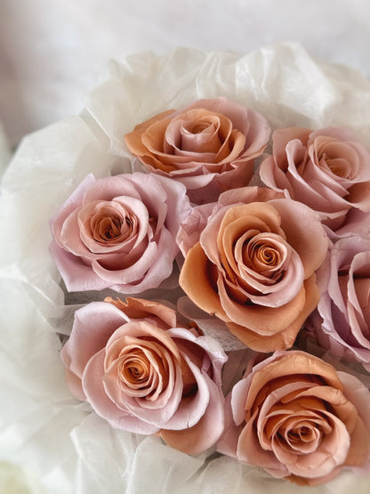 Close up view of a preserved roses bouquet with double tone roses in peach and pink tone