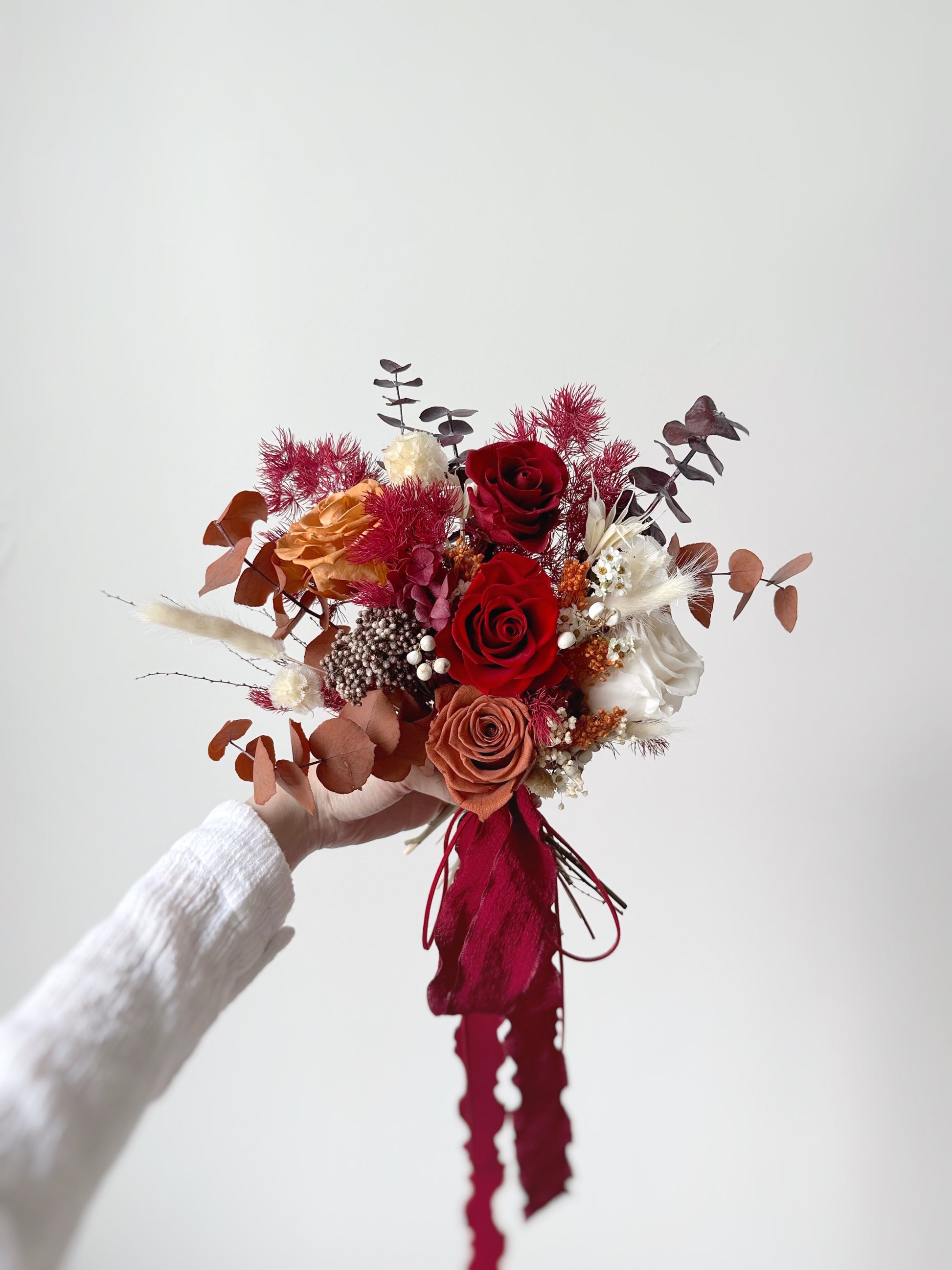The mix of deep maroon and golden undertones adds depth and richness to the bouquet’s overall look.
深栗色与金黄色调的融合，赋予捧花层次感与丰盈质感。