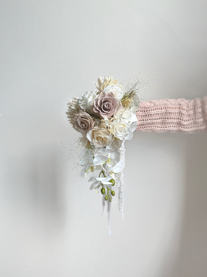 A cascading bouquet flowing beautifully from every angle, complementing the bride’s silhouette with effortless romance.
瀑布形捧花从各个角度都展现流畅美感，与新娘身形相映成趣，尽显浪漫气息。