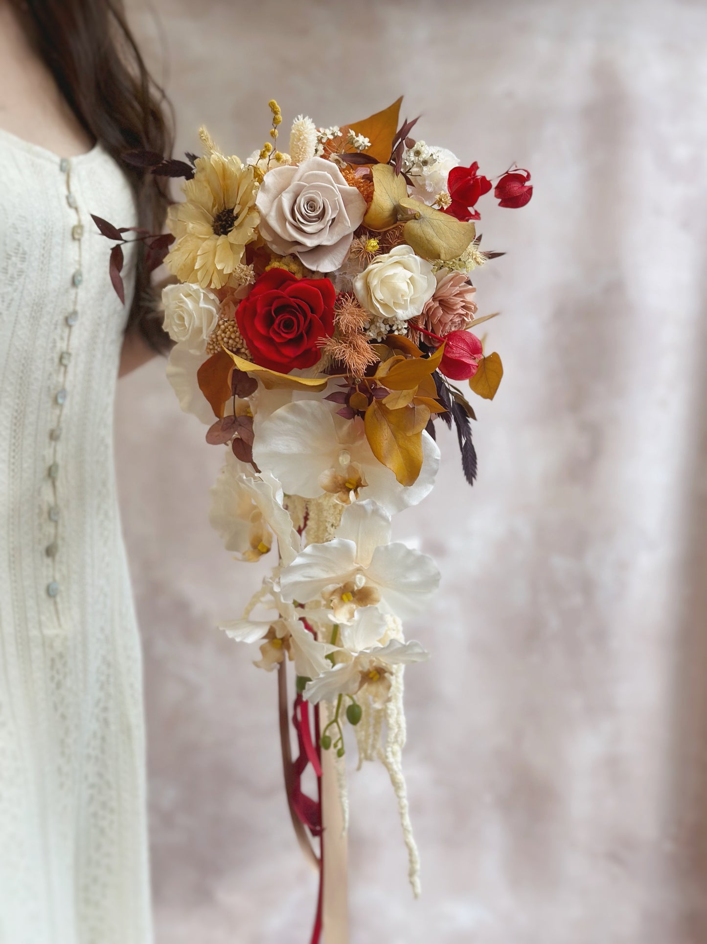 Front view of the preserved flowers teardrop bouquet, featuring preserved roses of various colours and other complementary fillers. Designed to complement warm-toned bridal gowns or rustic-themed weddings with its rich color palette.
色彩浓郁，完美搭配暖色系婚纱或乡村风婚礼。 