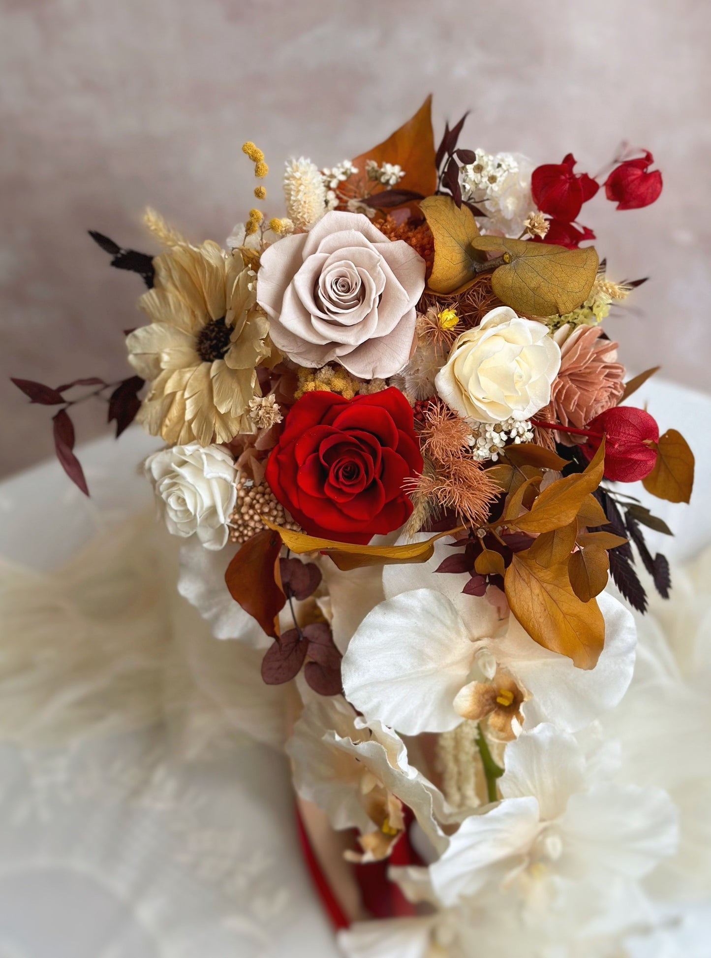 Close up view of the Autumn Whispers Bridal Bouquet. A close-up of the bouquet, highlighting the intricate textures of Phalaenopsis orchids, soft florals, and cascading elements.
捧花特写，展现蝴蝶兰、柔美花朵与垂坠花材的细腻层次。