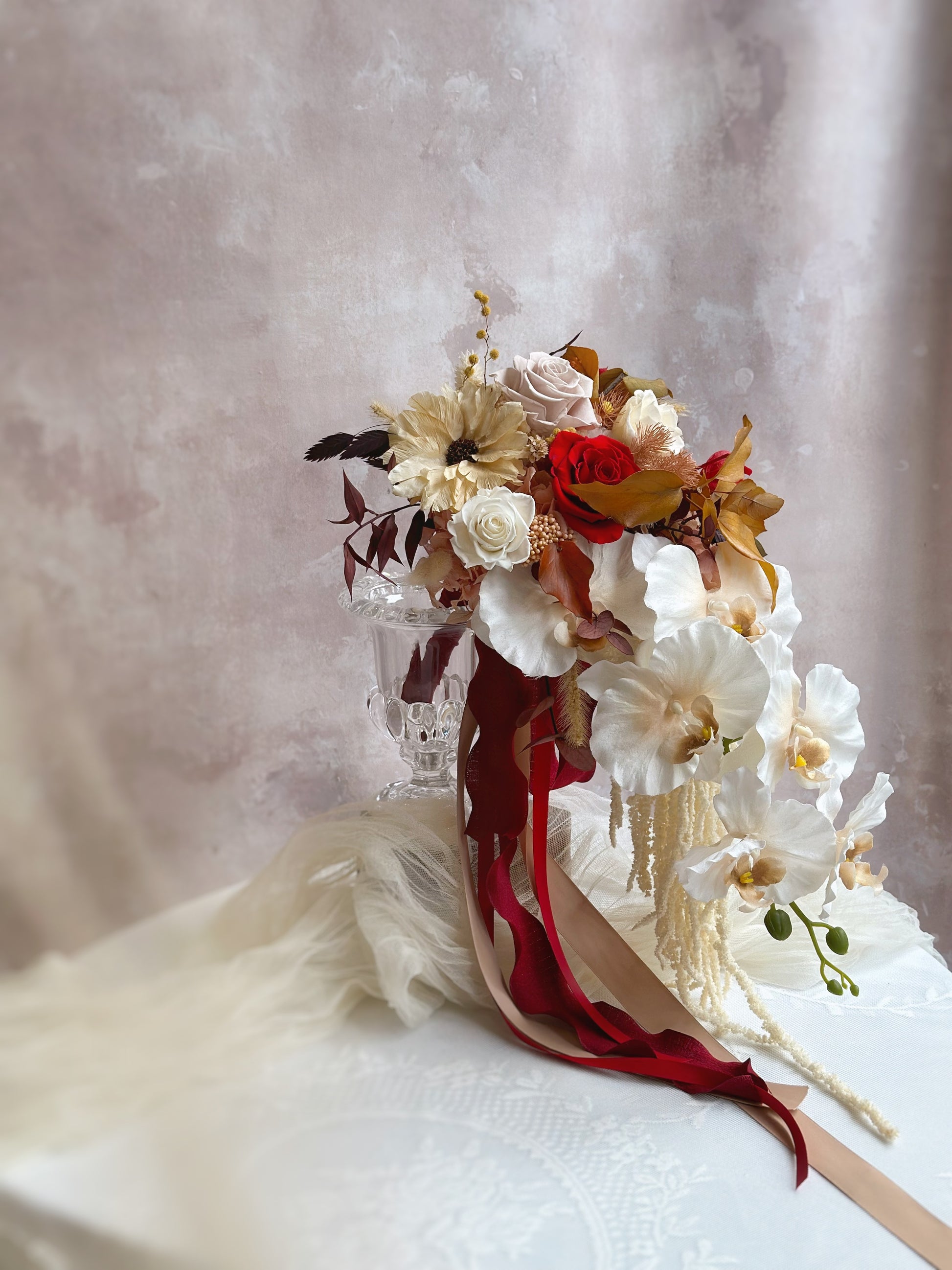 Side profile of the bouquet, emphasizing its elegant teardrop shape and cascading amaranths.
捧花侧视图，展现优雅的泪滴形轮廓及垂坠苋菜花的美感。