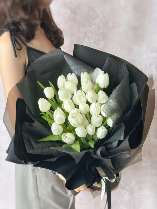 Holding a giant 30 stalks of white tulips bouquet with black wrappers