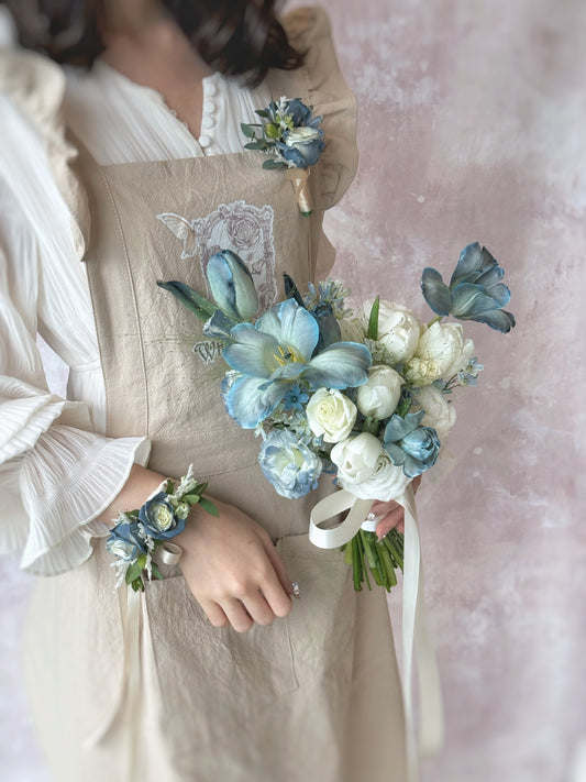 model wearing the 'blue haze' wrist corsage and boutonniere, matching design