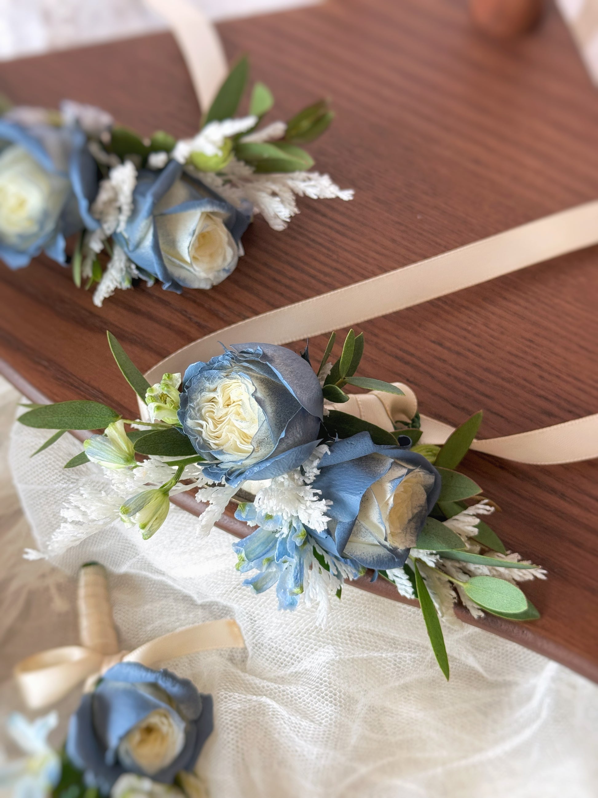 Close up view of spray roses wrist corsage in dusty blue color