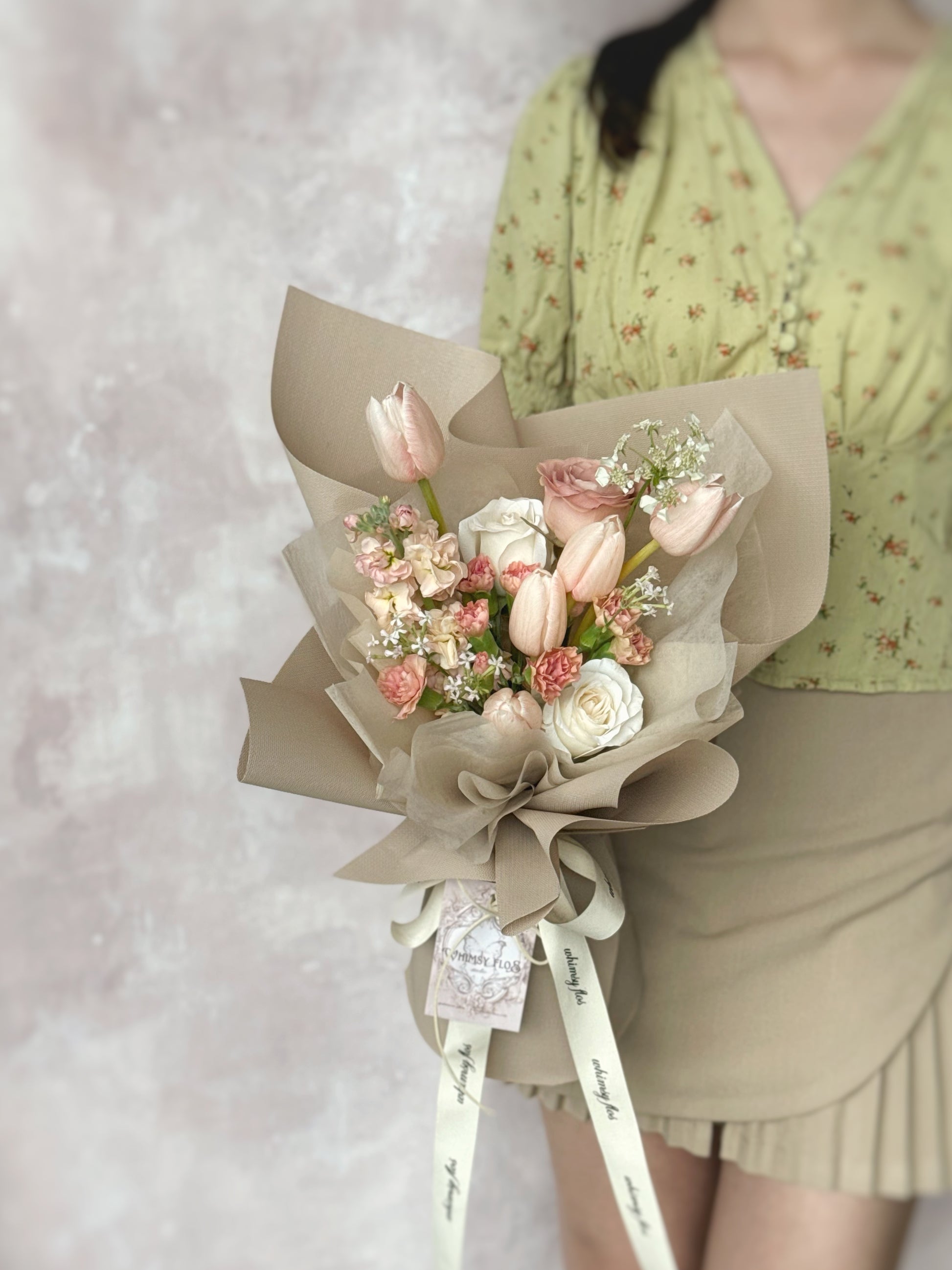 Model holding the Blushie Tulip bouquet, featuring soft blush-toned tulips arranged in a romantic, dainty style. 模特手持Blushie Tulip花束，柔和的腮红色郁金香以浪漫细腻的方式排列。