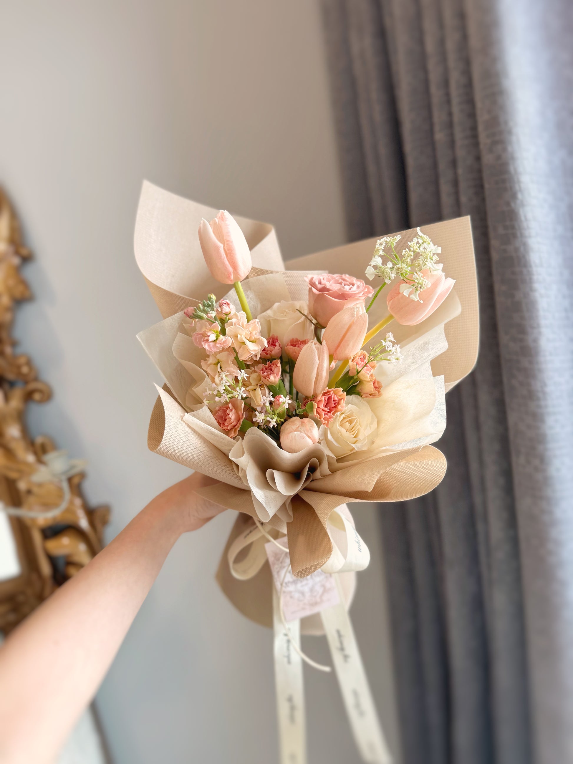 Close-up of hand holding the Blushie Tulip bouquet with delicate blush tulips, capturing its gentle and girly charm. 手持Blushie Tulip花束的特写镜头，展示柔美的腮红色郁金香，散发甜美可爱的气息。

