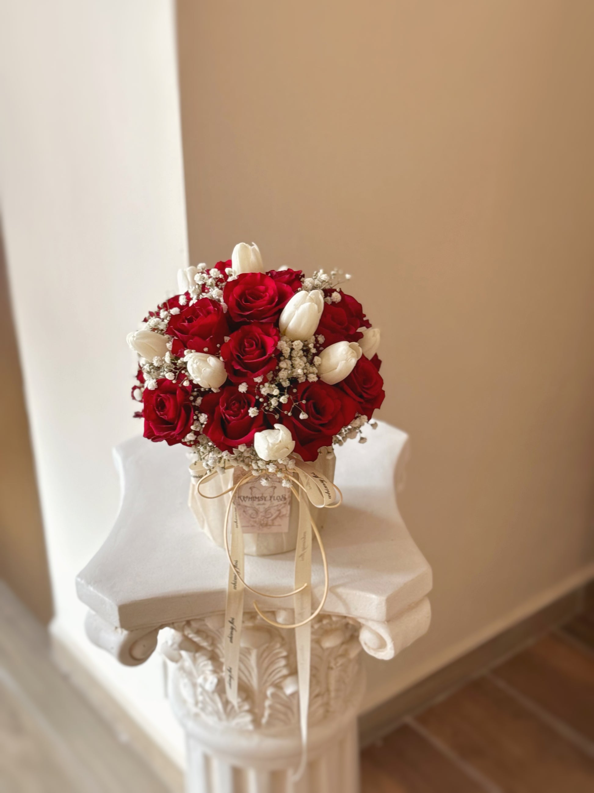  Front view of a dome-shaped flower box featuring red roses, white tulips, and baby’s breath, arranged with graceful balance and romantic charm.

正面展示圆顶花盒，融合红玫瑰、白郁金香与满天星，整体造型柔美，传递经典浪漫氛围。