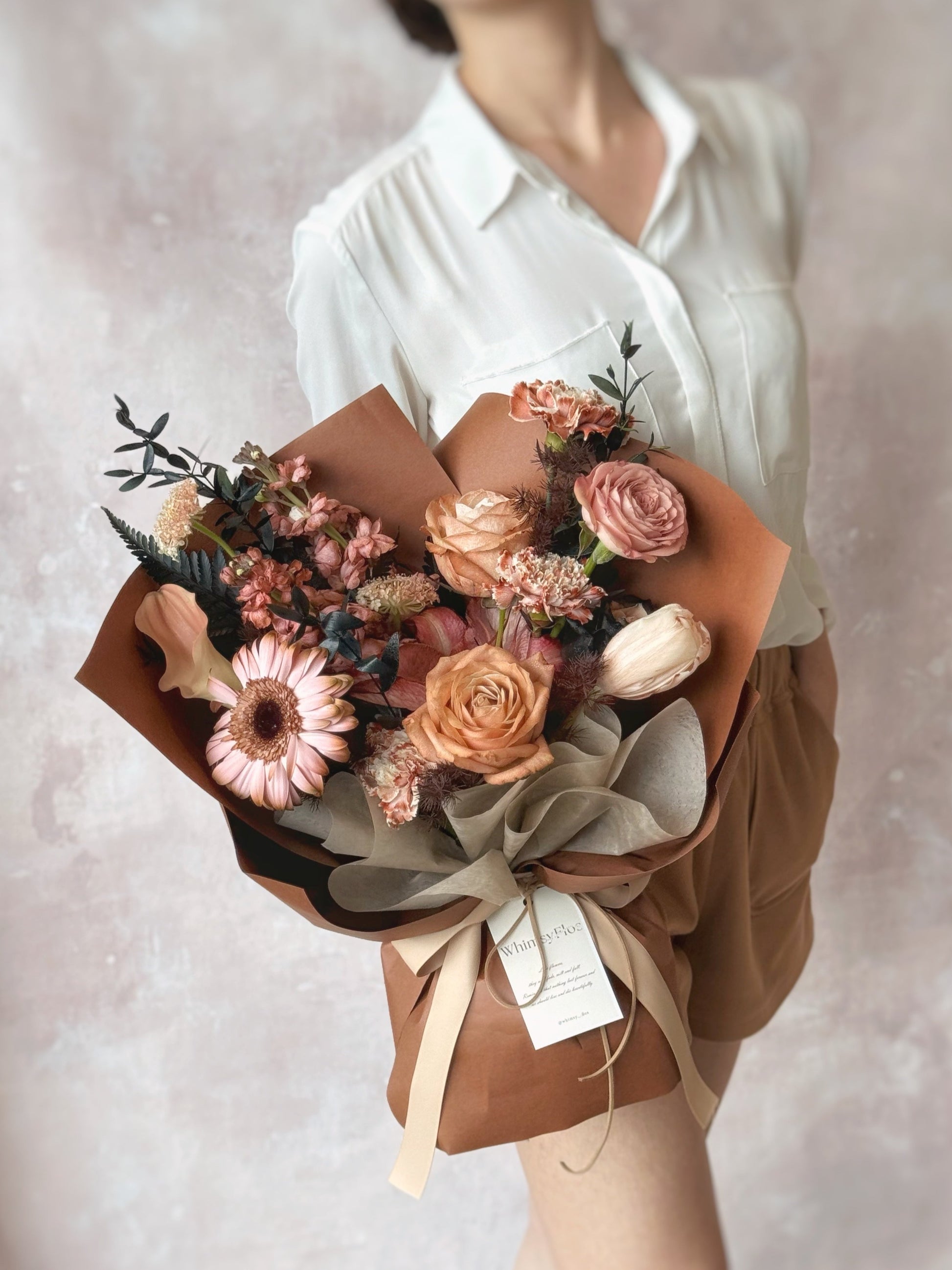 Stylish brown theme stem dyed mix fresh flowers bouquet.  A model holding the modern spray-painted bouquet, capturing the bold colors and unique design.
手持现代喷染花束的生活照，展现大胆色彩与独特设计。


