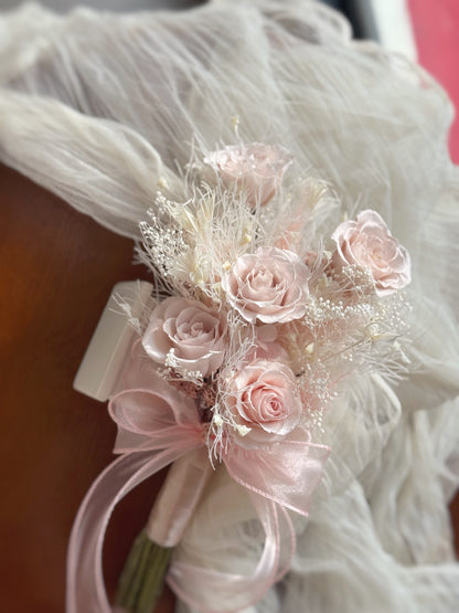 the Chloe bouquet displayed on a table, offering a full view of its delicate pink roses and soft hydrangeas, perfect for a sweet ROM bouquet.
“Chloe”花束放置在桌上，展示其细腻的粉色永生玫瑰和柔软的绣球花，完美适合作为甜美的登记结婚花束。