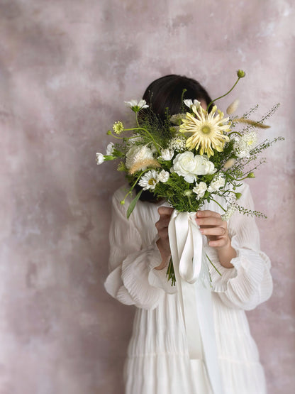 Flowing greenery and creamy florals create a soft, enchanting bridal bouquet
自然垂落的绿植搭配奶油色花卉，营造柔美迷人的婚礼捧花