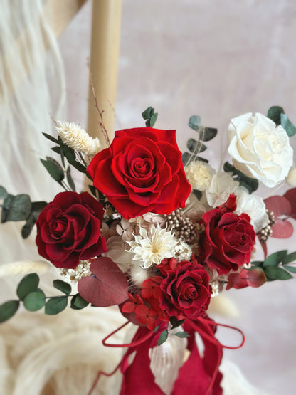 Close-up of the bouquet’s velvety crimson roses, contrasted beautifully against fresh green textures and soft white florals.
深红天鹅绒玫瑰的特写，与翠绿叶材和柔和白花形成迷人对比。