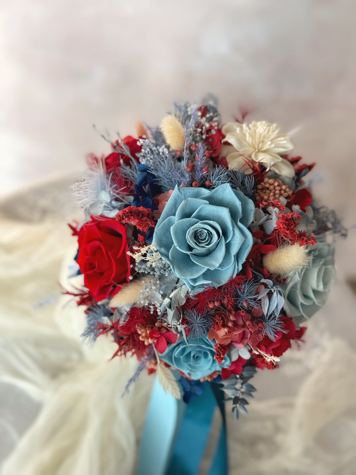 Crimson_sapphire_preserved_flowers_round shaped bridal_bouquet close view. A close-up of the bouquet resting on a table, highlighting the intricate textures and everlasting beauty of preserved flowers.
捧花静置桌面，展现永生花精致的质感与持久的美感