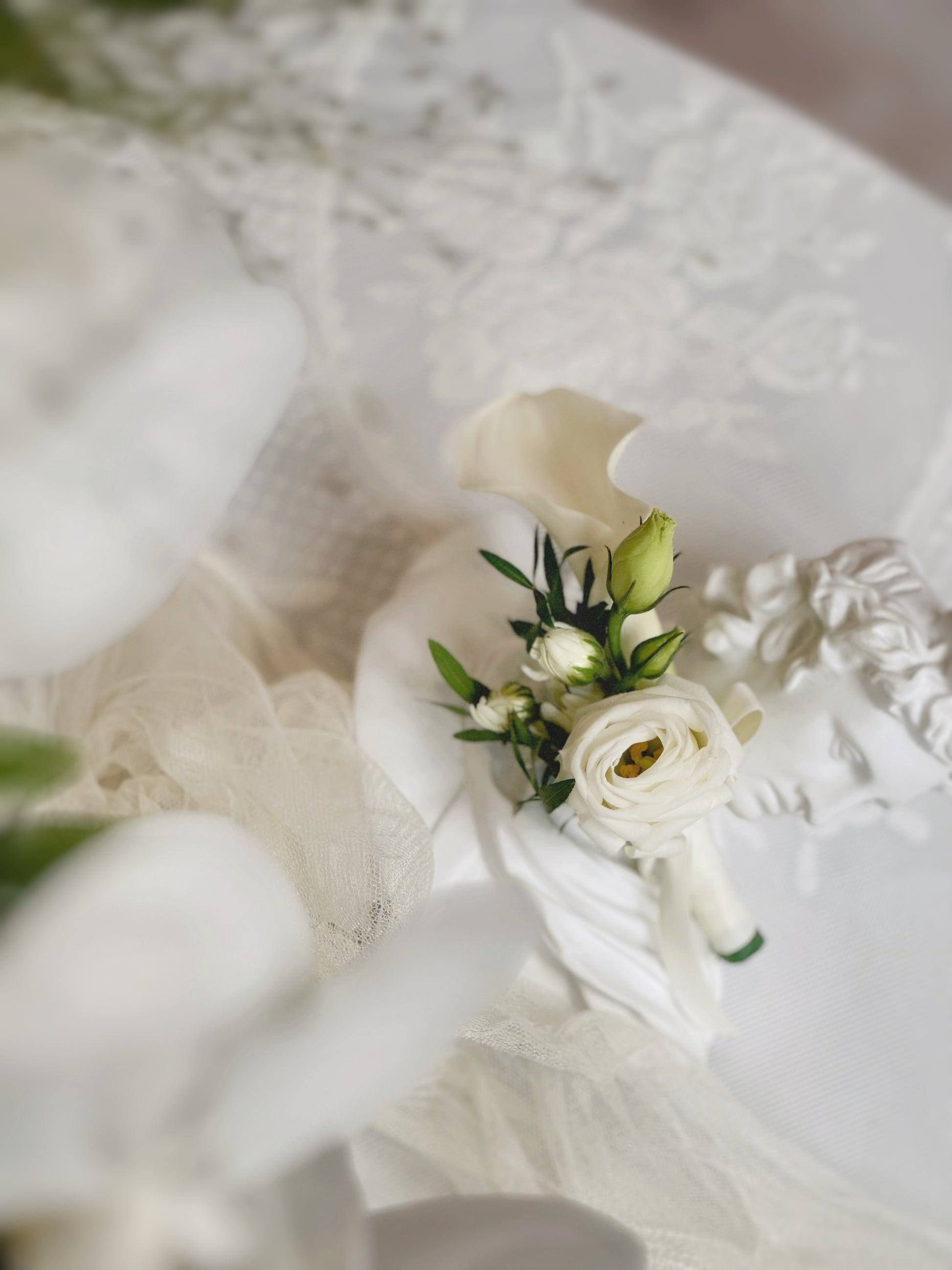 front view of delicate touch white calla lily corsage, this design matches beautifully with our teardrop bridal bouquet
