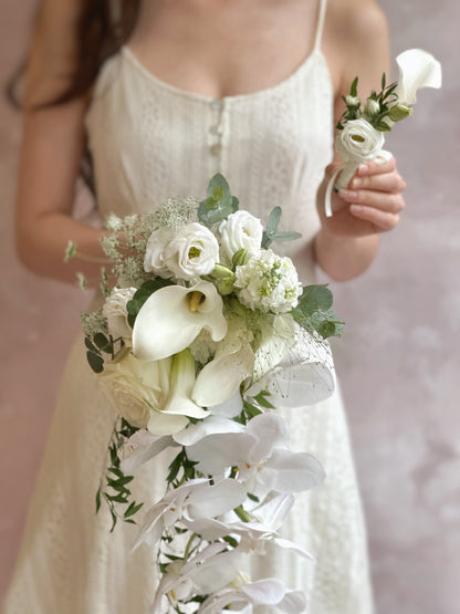 Bridal bouquet with cascading phalaenopsis orchids and matching groom's calla lily boutonniere for a perfect wedding duo
新娘捧花与新郎白色马蹄莲胸花搭配，蝴蝶兰垂坠设计，婚礼完美组合