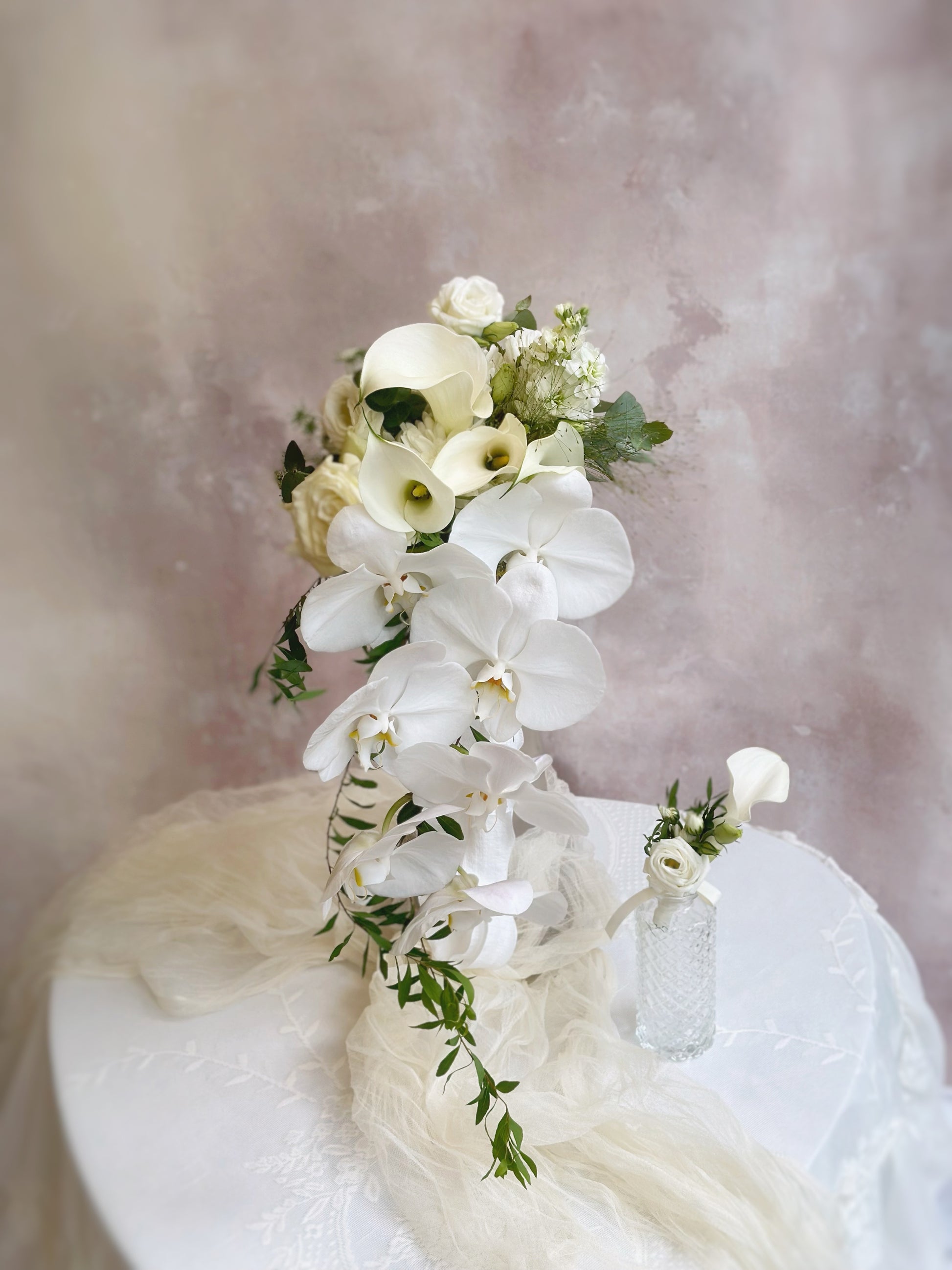 White orchid bridal bouquet and boutonniere set for a sophisticated wedding look
纯白蝴蝶兰新娘捧花与胸花组合，打造高雅婚礼造型