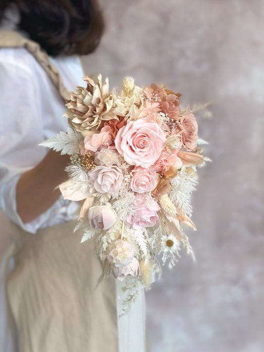 A bride holding the cascading bouquet, its elegant ombré tones complementing a mermaid-style wedding gown.
新娘手持瀑布形捧花，优雅渐变色调完美搭配美人鱼婚纱。