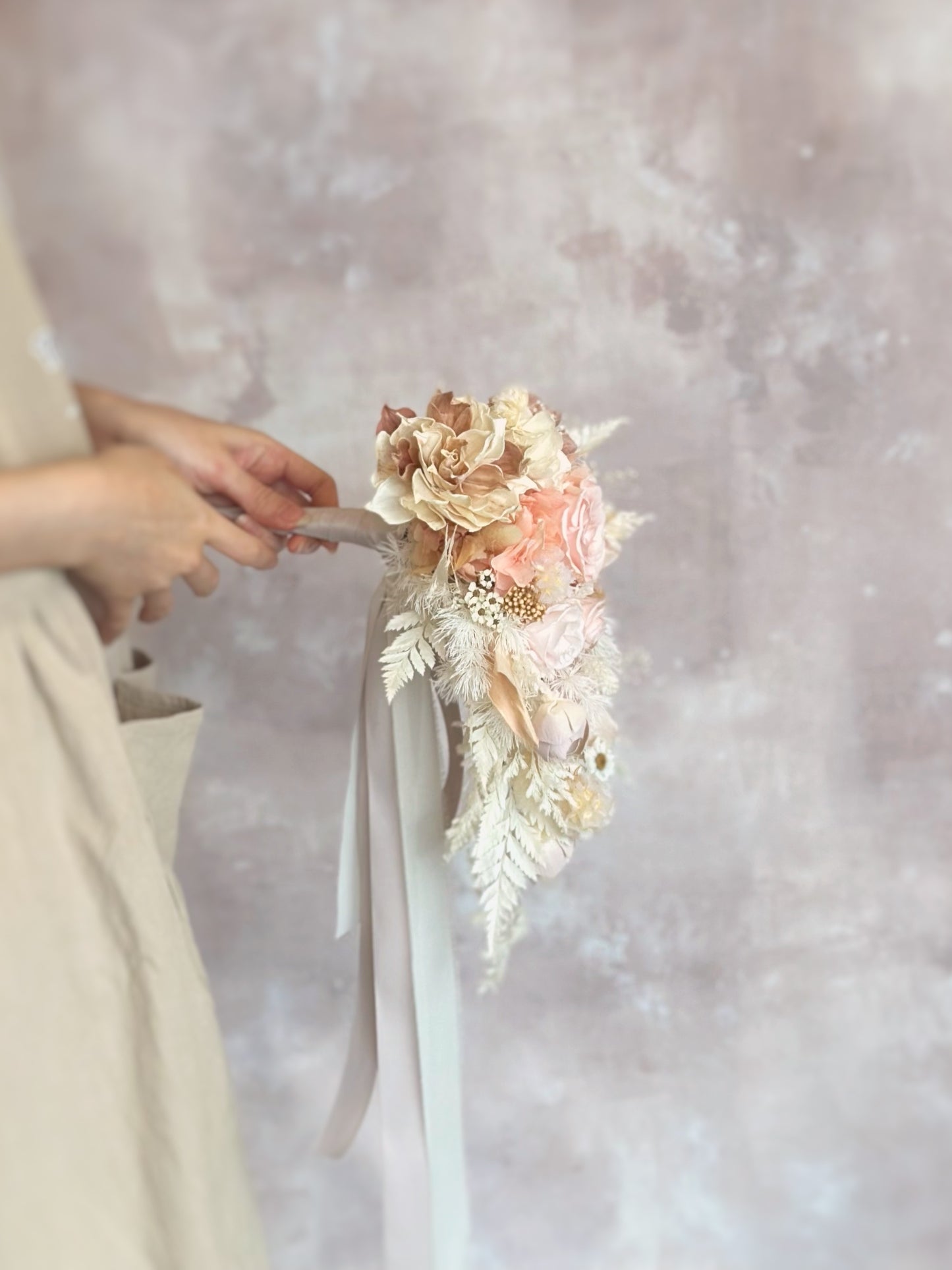 Side profile of the bouquet, highlighting the cascading florals that create a flowing, graceful silhouette.
捧花侧视图，展现自然垂坠的花材，打造流畅优雅的轮廓。