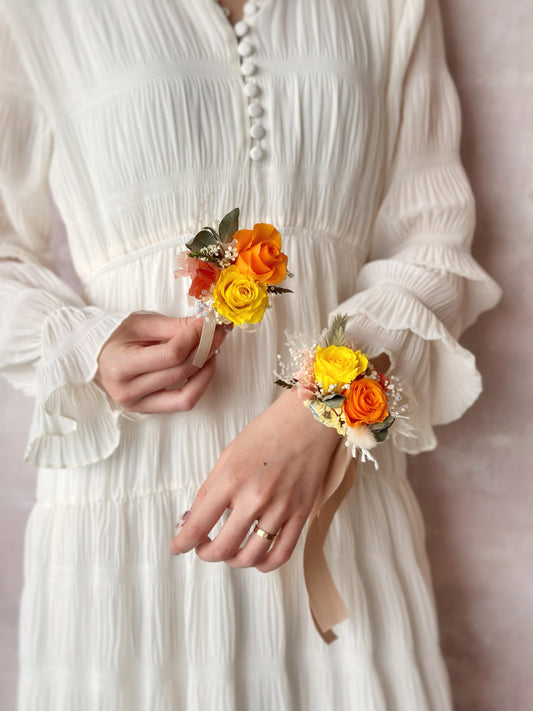 Model wearing double tansy wrist corsage and holding the boutonniere
