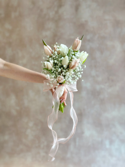 Bouquet held at arm’s length, showcasing the tulips’ soft beauty and delicate textures.
仅展示手臂与手部延伸握花画面，突显郁金香的柔美细节与温柔气质。