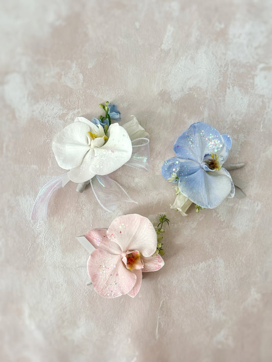 Fairy Dust Orchid corsage with glittery Phalaenopsis orchid petals, showcasing its elegant and ethereal design on a delicate ribbon