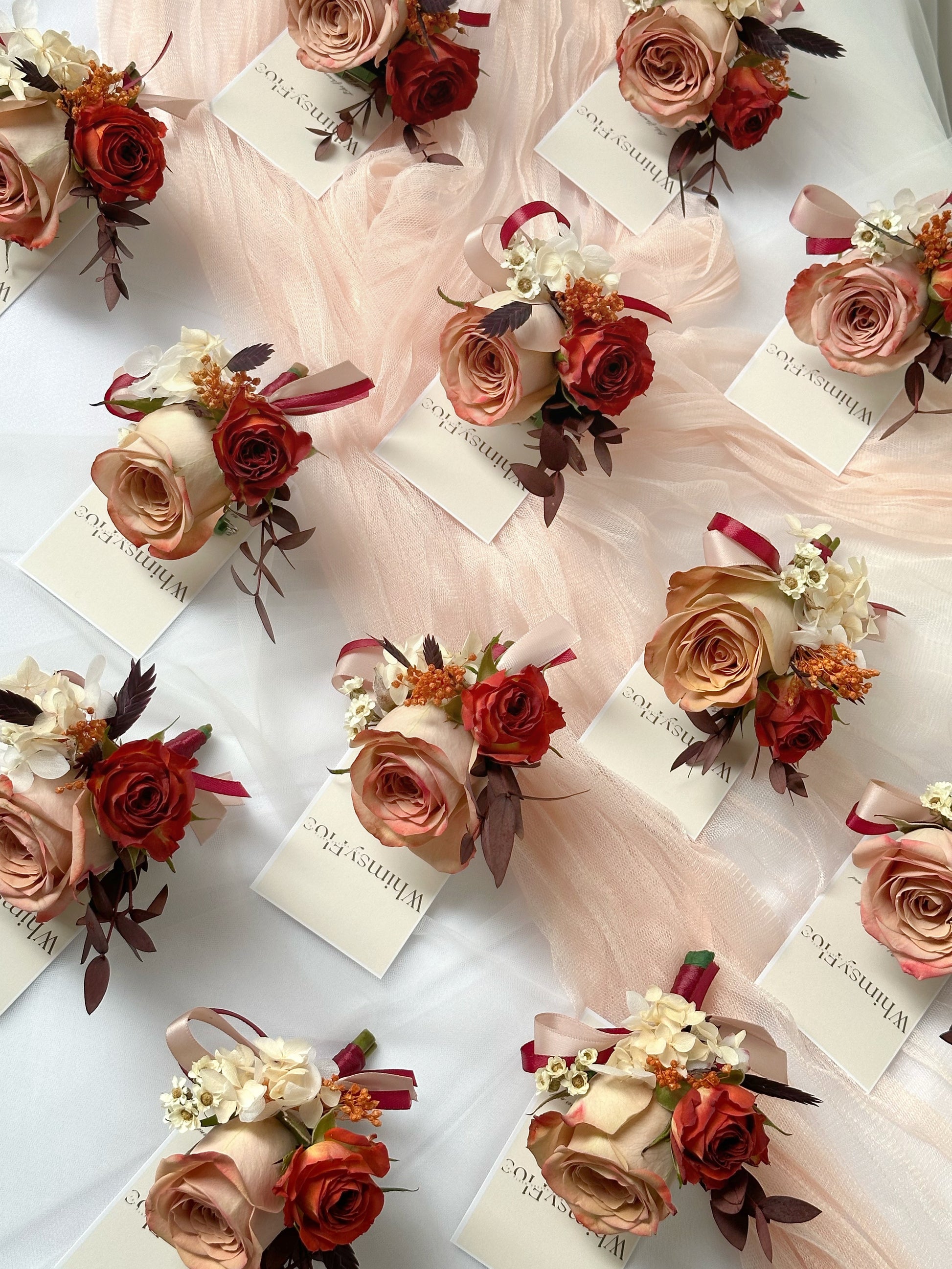 Top view of multiple Faye fresh cappuccino rose corsage in bulk for wedding reception