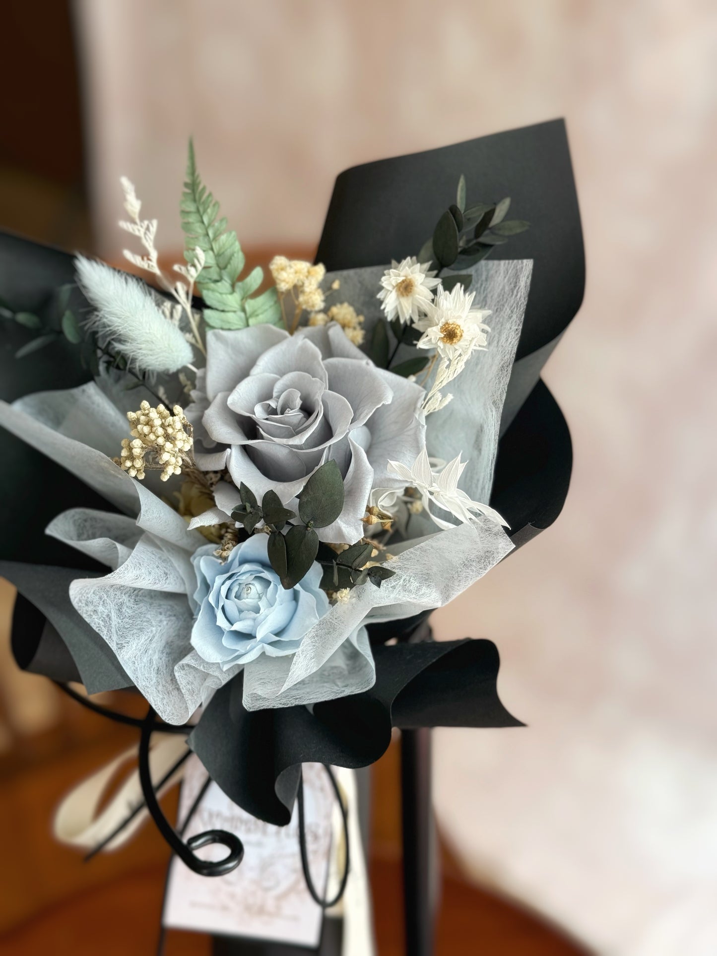 A close-up view of the Finn bouquet, highlighting the deep black and rich blue preserved roses wrapped in a clean, minimalistic style.
“Finn”花束的特写，突出了深黑色和浓郁蓝色的永生玫瑰，包裹在简洁、极简风格中。