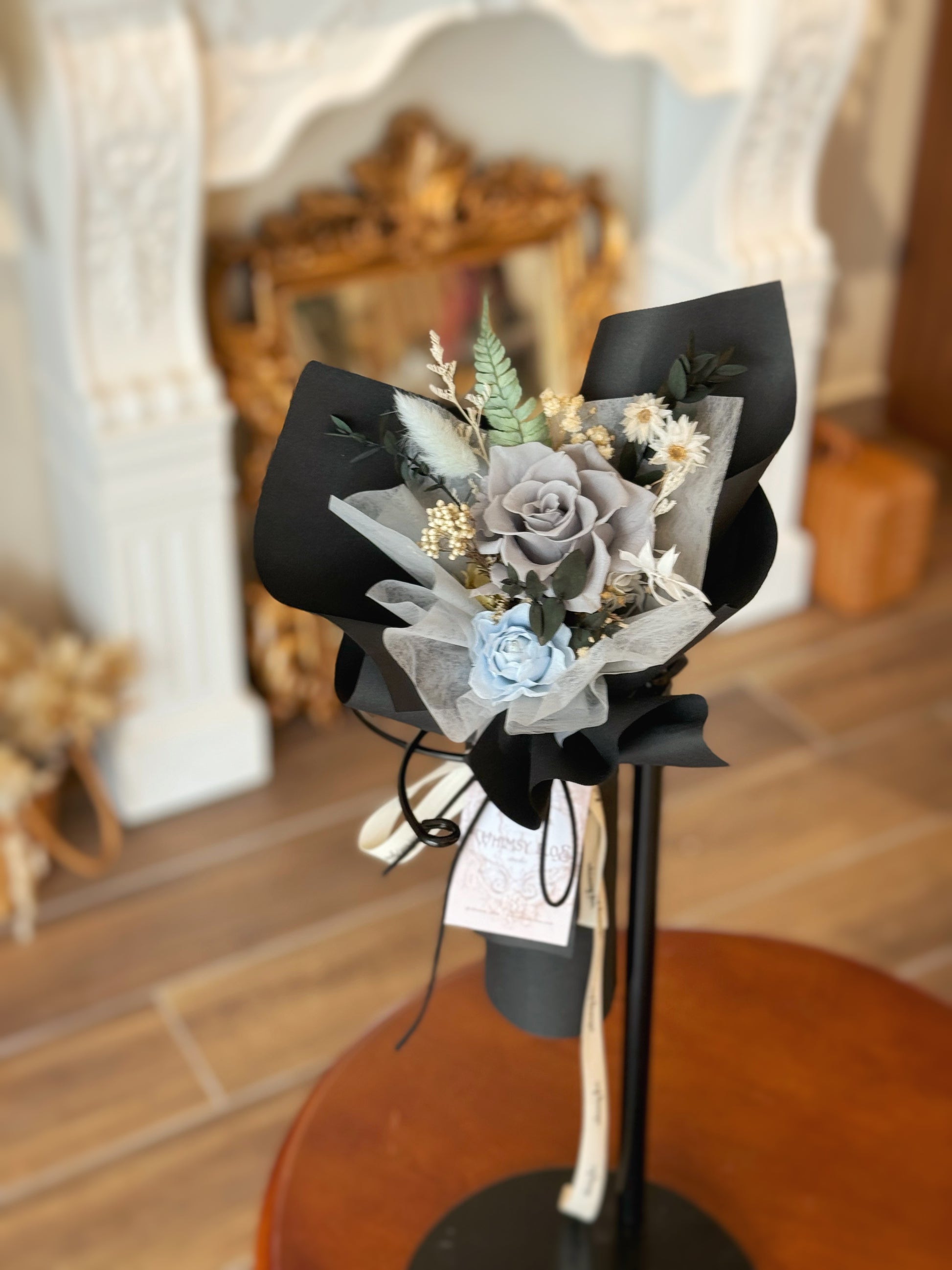 Finn bouquet displayed on a table, providing a full view of the sleek and sophisticated arrangement with its dark tones and minimalistic style.
“Finn”花束放置在桌上，展示其简洁精致的排列，深色调与极简风格完美融合。