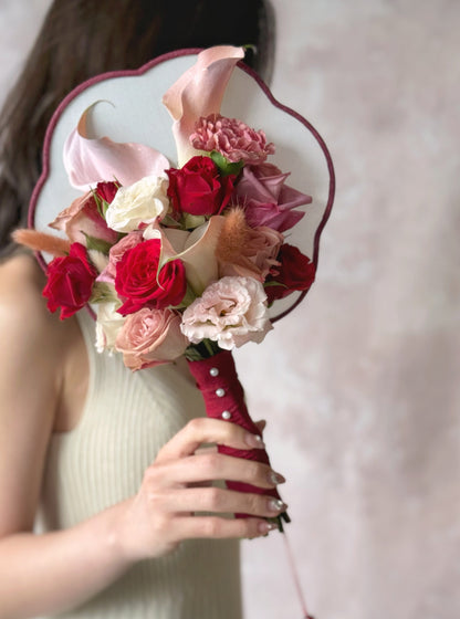 Bride holding a floral bridal fan bouquet, symbolizing tradition and grace with a modern twist
新娘手持鲜花扇花束，象征传统与优雅，并融入现代设计感