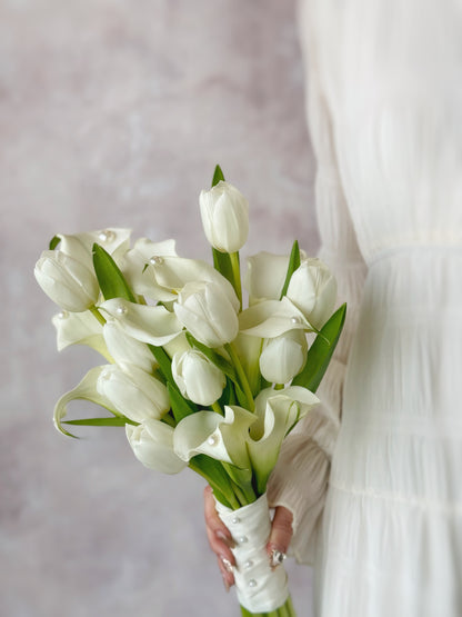 Genuine fresh flowers bridal bouquet calla lily holding the bouquet
新娘手持优雅排列的马蹄莲与郁金香捧花，打造精致现代新娘造型

