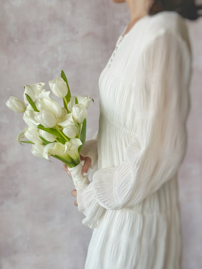 Genuine fresh flowers bridal bouquet calla lily side view, an elegant floral details of a calla lily and tulip bouquet, ideal for minimalist brides seeking a modern yet romantic touch
韩式极简新娘捧花细节，突出马蹄莲与郁金香的光滑花瓣与优美线条


