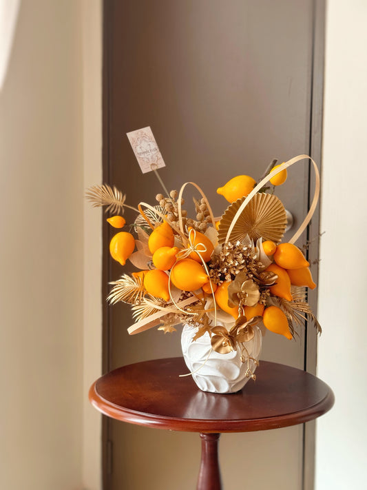 chinese new year floral arrangement featuring nipplefruits, golden ornaments in vase, symbolizing prosperity and good fortune. An auspicious gift for family, friends or business partners.