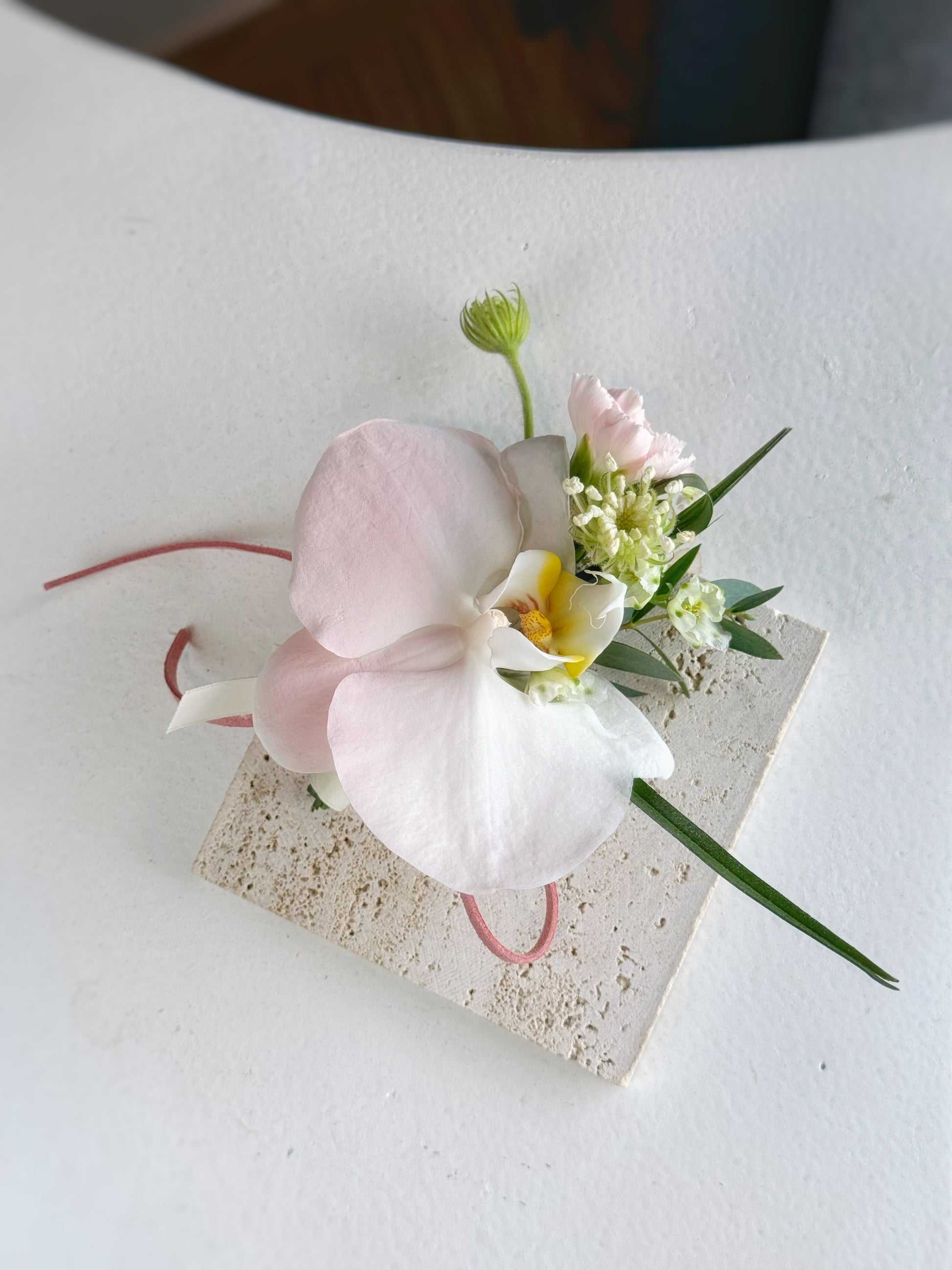 top view of pastel pink spray painted phalaenopsis orchid corsage