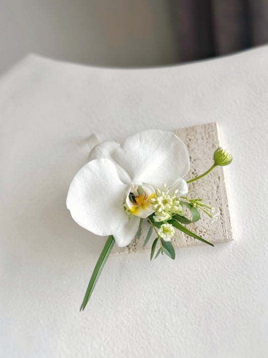 Elegant Phalaenopsis orchid corsage with seasonal fillers and foliage, featuring a graceful and timeless design