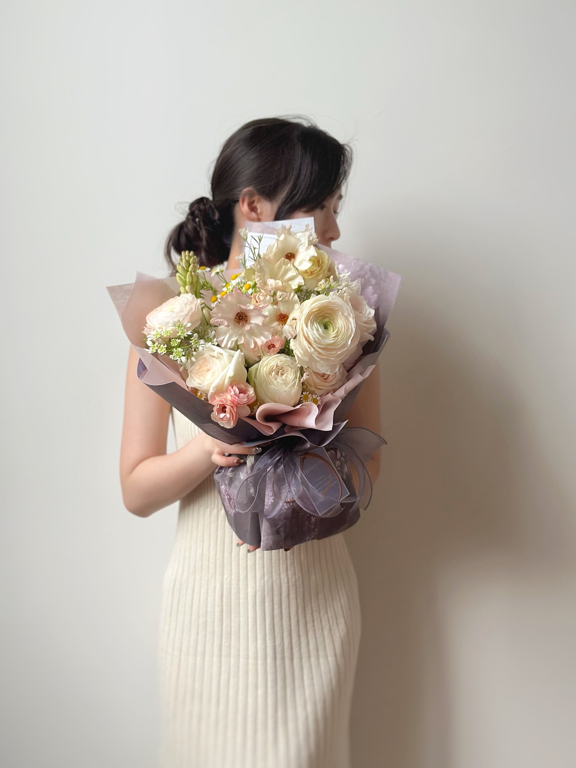 A model holding the soft-toned bouquet, capturing its gentle and calming aesthetic.
手持柔和色调花束的生活照，传递出宁静温柔的气息。
