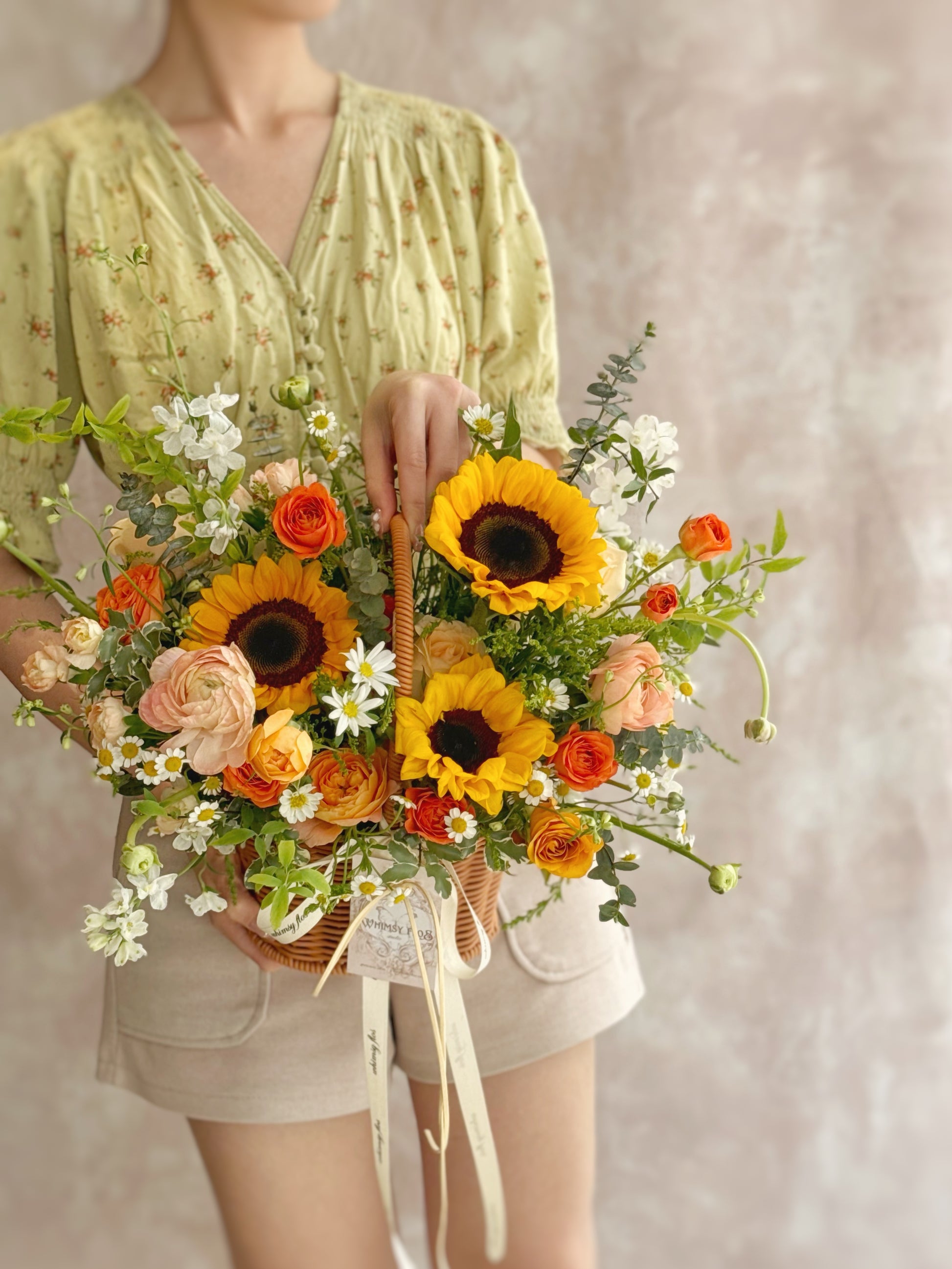Basket held by model, capturing the cheerful, sunlit energy of the floral design in a joyful real-life setting.

模特手持花篮，记录阳光花艺的温暖活力与真实的愉悦氛围