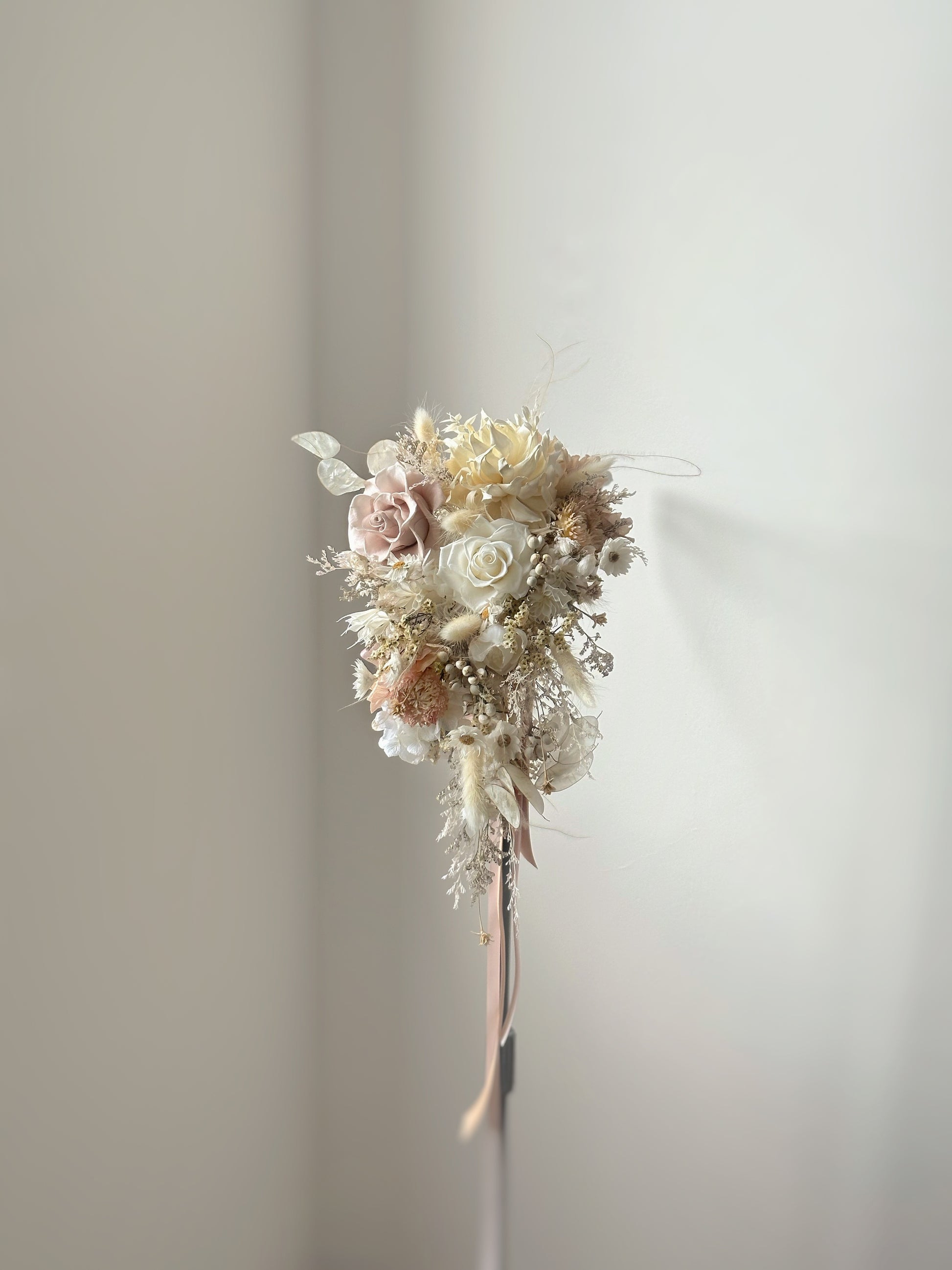 Front view of Pastel cream tone cascading preserved flowers bridal bouquet 