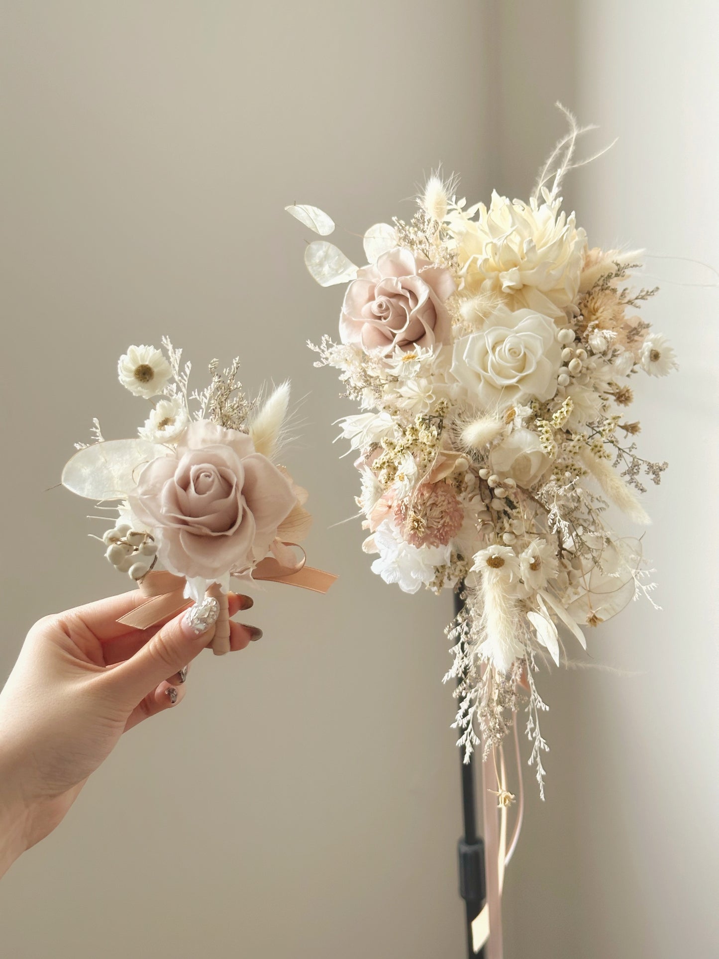 Pastel cream tone cascading preserved flowers bridal bouquet with groom's boutonniere close up view