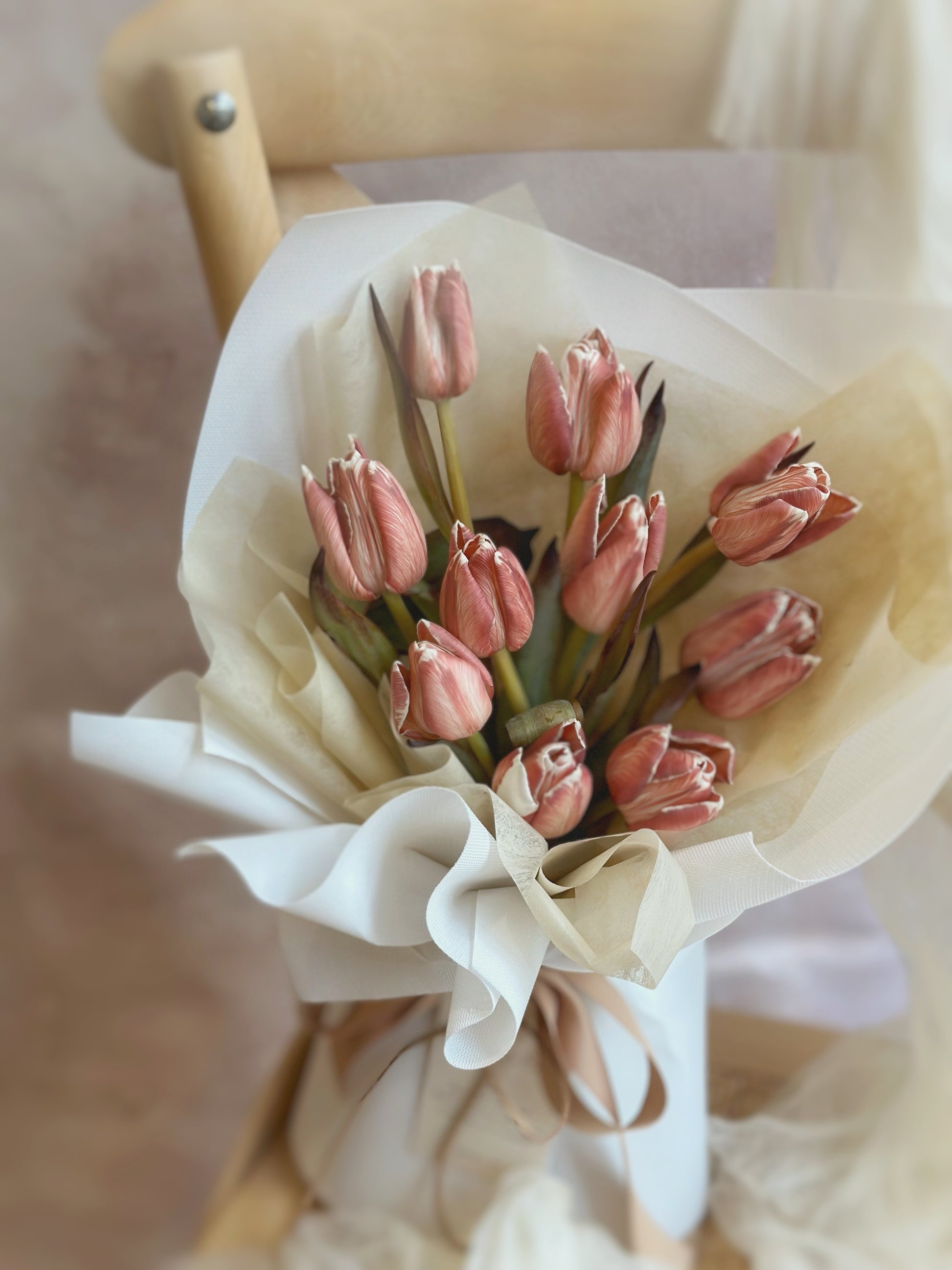 Close up view of a rustic brownie stem dyed tulips on a chair 