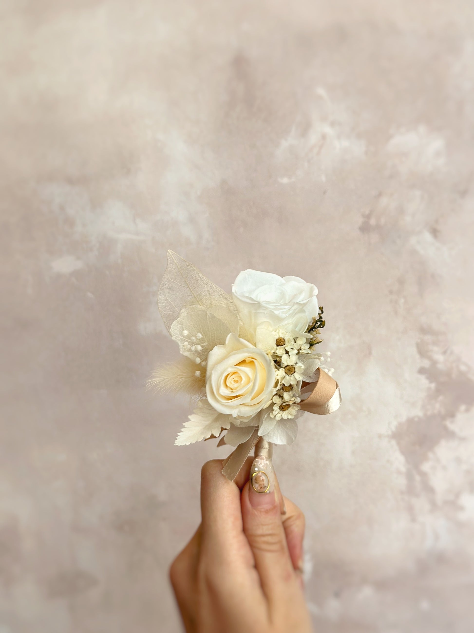 Double preserved roses boutonniere in cream and white color theme for wedding 